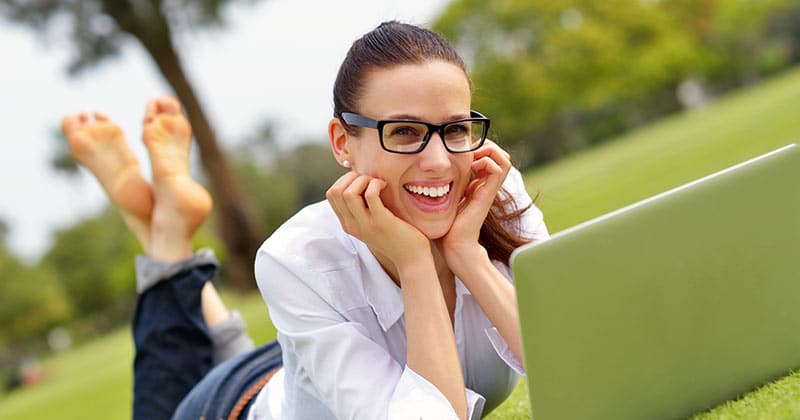Woman smiling while studying outside