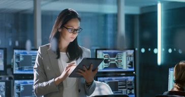 Woman standing using tablet inside computer lab