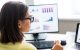 Women overseeing various charts on computer screens