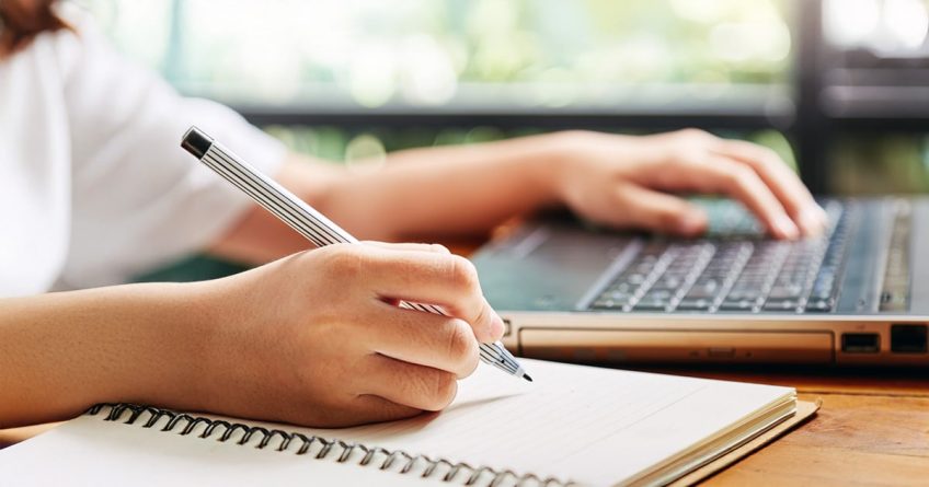 Young woman writing and taking notes